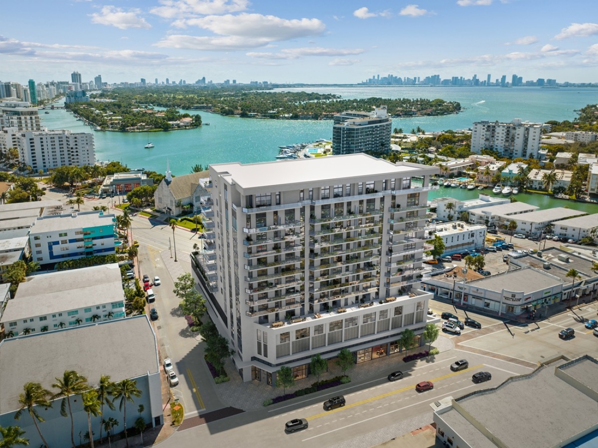 Aerial view of the PALMA Miami Beach tower rising over the surrounding neighborhood with Biscayne Bay in the background