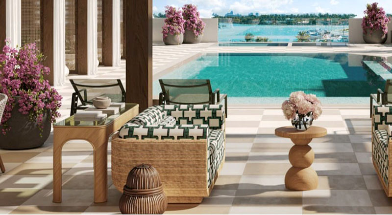 Covered lounge terrace with rattan furniture and bougainvillea overlooking the pool and marina