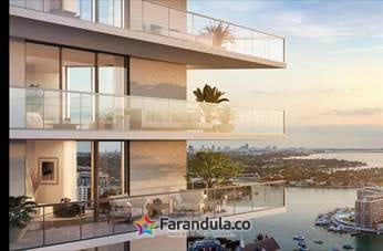 Close-up of curved glass balconies at PALMA Miami Beach with the bay in the background