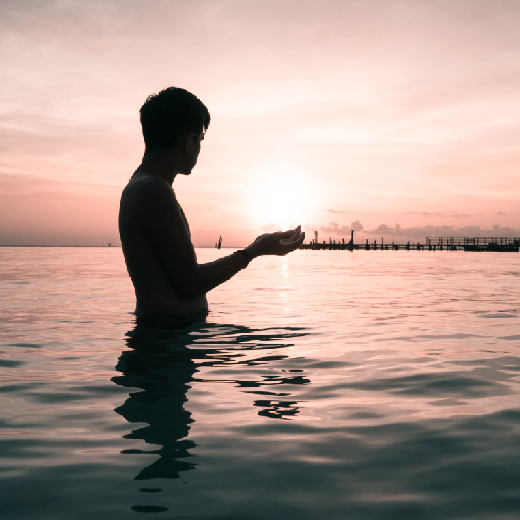 person standing waist deep in ocean