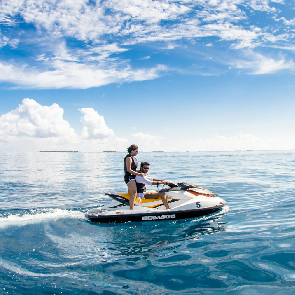 couple on Sea-Doo, jet-skiing on the ocean