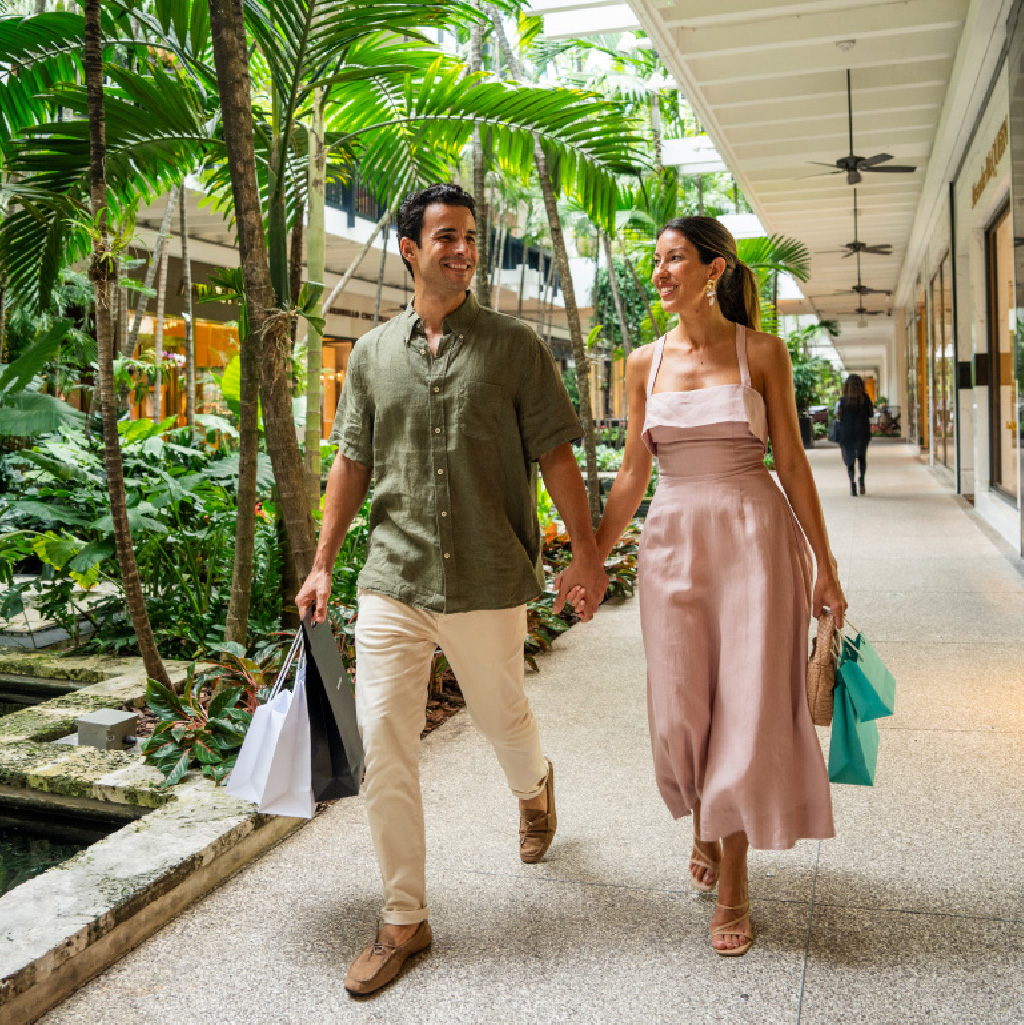 couple walking in ourdoor shopping mall lined with palm trees