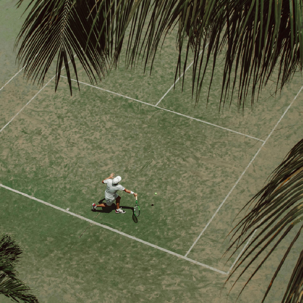 person playing tennis on grass tennis court