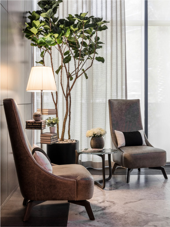 corner of lobby with two chairs, plant, and lamp